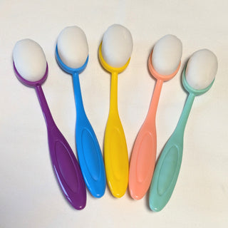 Set of five large colorful ink blending brushes with bright purple, blue, yellow, pink, and green handles arranged for card making.